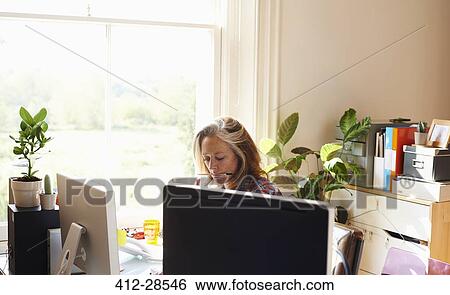 Focused woman working in home office View Large Photo Image Stock Photograph - Focused woman working in home office. Fotosearch