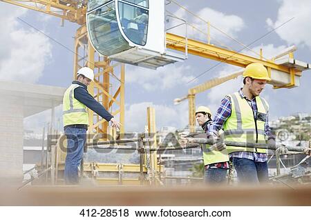 Foreman guiding construction workers below crane at construction site View Large Photo Image Stock Photo - Foreman guiding construction workers below crane at construction site. Fotosearch
