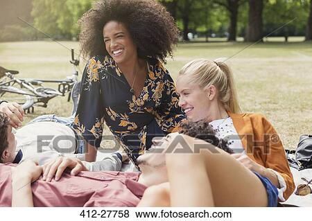 Stock Photo - Friends hanging out relaxing in park. Fotosearch