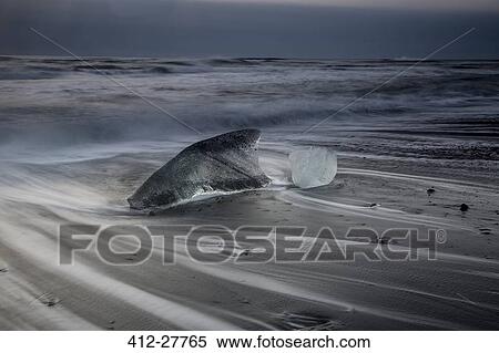 Stock Photography - Ice on stormy cold ocean beach, Iceland. Fotosearch