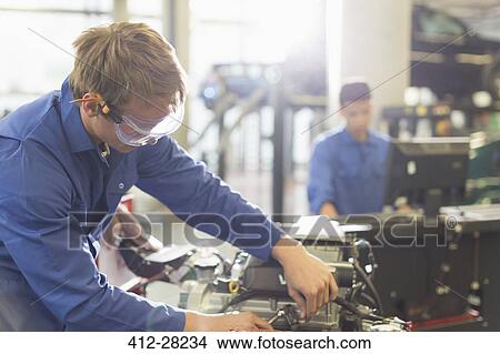 Mechanic working on engine in auto repair shop View Large Photo Image Picture - Mechanic working on engine in auto repair shop. Fotosearch