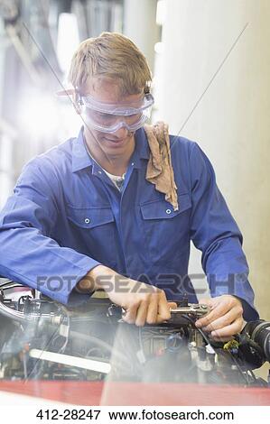 Mechanic working on engine in auto repair shop View Large Photo Image Stock Photo - Mechanic working on engine in auto repair shop. Fotosearch