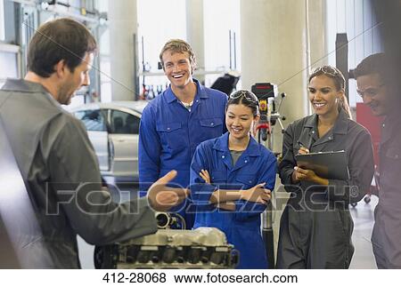 Mechanics discussing car engine in auto repair shop View Large Photo Image Stock Photo - Mechanics discussing car engine in auto repair shop. Fotosearch