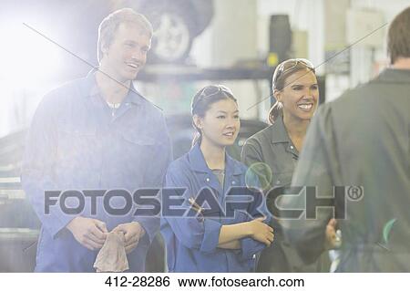 Stock Photograph - Mechanics listening in auto repair shop. Fotosearch