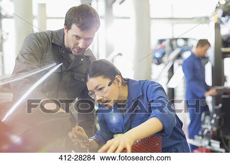 Mechanics working on engine in auto repair shop View Large Photo Image Picture - Mechanics working on engine in auto repair shop. Fotosearch