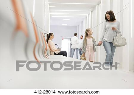 Mother and daughter holding hands walking in hospital corridor View Large Photo Image Picture - Mother and daughter holding hands walking in hospital corridor. Fotosearch