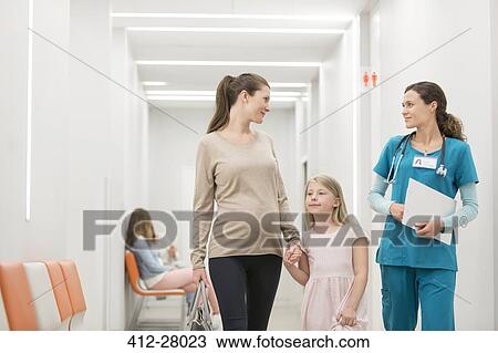 Nurse talking to mother and daughter in hospital corridor View Large Photo Image Stock Image - Nurse talking to mother and daughter in hospital corridor. Fotosearch