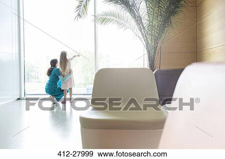 Nurse with pointing girl at hospital lobby window View Large Photo Image Stock Photo - Nurse with pointing girl at hospital lobby window. Fotosearch