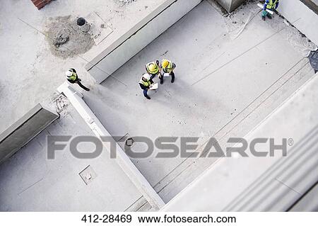 Overhead view of construction workers and engineers at construction site View Large Photo Image Stock Photo - Overhead view of construction workers and engineers at construction site. Fotosearch