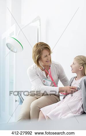 Pediatrician using stethoscope on girl patient in examination room View Large Photo Image Stock Image - Pediatrician using stethoscope on girl patient in examination room. Fotosearch