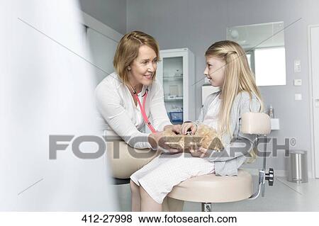 Pediatrician using stethoscope on girl patient’s teddy bear in examination room View Large Photo Image Stock Photo - Pediatrician using stethoscope on girl patient’s teddy bear in examination room. Fotosearch