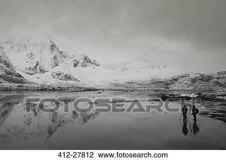 Photographers below snow covered mountains and calm bay, Norway View Large Photo Image Stock Image - Photographers below snow covered mountains and calm bay, Norway. Fotosearch