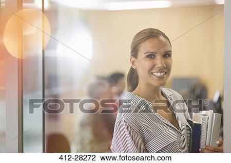 Portrait confident businesswoman with books in office View Large Photo Image Stock Image - Portrait confident businesswoman with books in office. Fotosearch
