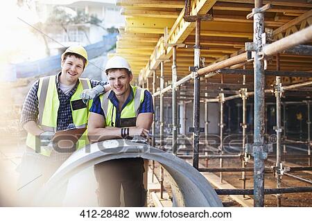 Stock Image - Portrait confident engineers with clipboard at construction site. Fotosearch