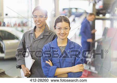 Portrait confident female mechanics in auto repair shop View Large Photo Image Stock Image - Portrait confident female mechanics in auto repair shop. Fotosearch