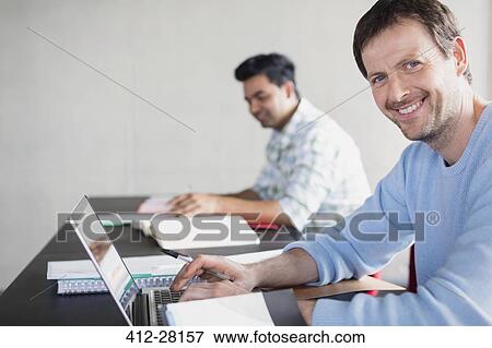 Stock Photo - Portrait confident man at laptop in adult education classroom. Fotosearch
