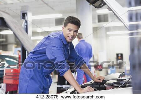 Portrait confident mechanic leaning over car engine in auto repair shop View Large Photo Image Stock Photo - Portrait confident mechanic leaning over car engine in auto repair shop. Fotosearch