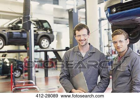 Portrait confident mechanics in auto repair shop View Large Photo Image Stock Photo - Portrait confident mechanics in auto repair shop. Fotosearch