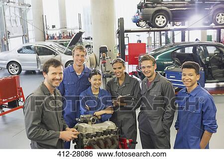 Portrait confident mechanics with car engine in auto repair shop View Large Photo Image Stock Photograph - Portrait confident mechanics with car engine in auto repair shop. Fotosearch