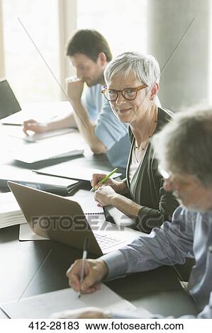Stock Image - Portrait confident senior woman studying in adult education classroom. Fotosearch