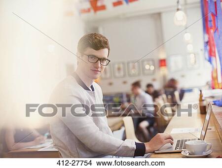 Picture - Portrait man using laptop in cafe. Fotosearch