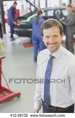 Portrait smiling businessman in auto repair shop View Large Photo Image Stock Image - Portrait smiling businessman in auto repair shop. Fotosearch
