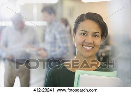 Stock Image - Portrait smiling businesswoman in office. Fotosearch