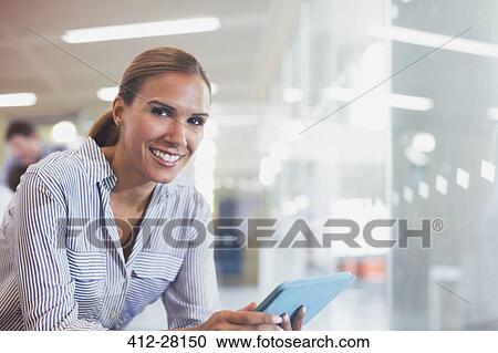 Stock Image - Portrait smiling businesswoman using digital tablet. Fotosearch