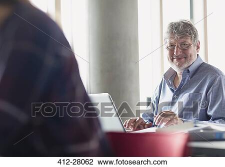 Portrait smiling man working at laptop in adult education classroom View Large Photo Image Stock Image - Portrait smiling man working at laptop in adult education classroom. Fotosearch