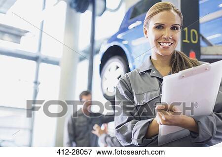 Portrait smiling mechanic with clipboard in auto repair shop View Large Photo Image Stock Photo - Portrait smiling mechanic with clipboard in auto repair shop. Fotosearch