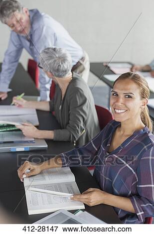 Portrait smiling student with textbook in adult education classroom View Large Photo Image Stock Photo - Portrait smiling student with textbook in adult education classroom. Fotosearch