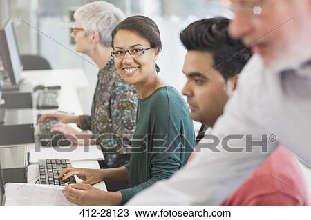 Portrait smiling woman at computer in adult education classroom View Large Photo Image Stock Image - Portrait smiling woman at computer in adult education classroom. Fotosearch