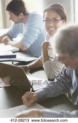 Stock Image - Portrait smiling woman studying in adult education classroom. Fotosearch