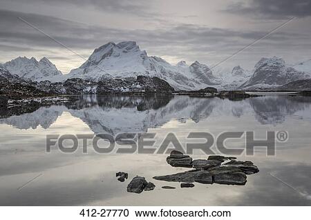 Reflection of snow covered mountain range in calm lake, Norway View Large Photo Image Stock Image - Reflection of snow covered mountain range in calm lake, Norway. Fotosearch