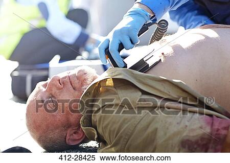 Rescue worker using defibrillator on unconscious car accident victim View Large Photo Image Stock Photography - Rescue worker using defibrillator on unconscious car accident victim. Fotosearch