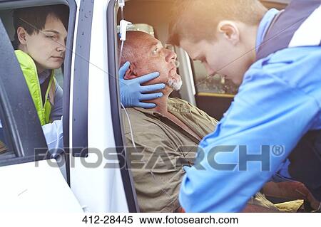 Rescue workers carefully tending to car accident victim in car View Large Photo Image Stock Photography - Rescue workers carefully tending to car accident victim in car. Fotosearch