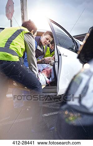 Rescue workers removing car accident victim from car View Large Photo Image Stock Image - Rescue workers removing car accident victim from car. Fotosearch