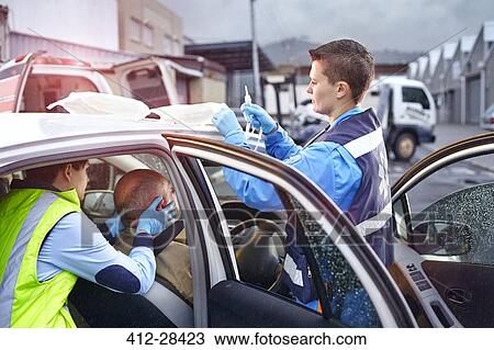 Rescue workers tending to car accident victim in car View Large Photo Image Stock Image - Rescue workers tending to car accident victim in car. Fotosearch