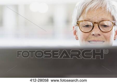Stock Photo - Senior businesswoman with eyeglasses using computer. Fotosearch
