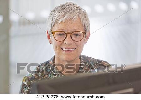 Stock Photograph - Senior businesswoman working at computer. Fotosearch