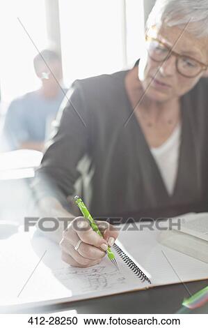 Senior woman doing homework in adult education classroom View Large Photo Image Stock Image - Senior woman doing homework in adult education classroom. Fotosearch