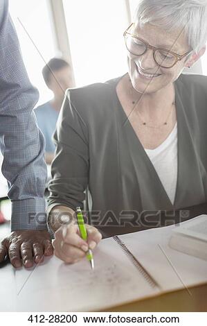 Senior woman reviewing homework in adult education classroom View Large Photo Image Stock Image - Senior woman reviewing homework in adult education classroom. Fotosearch