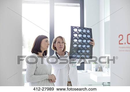 Serious doctor and patient reviewing x-rays in examination room View Large Photo Image Stock Photo - Serious doctor and patient reviewing x-rays in examination room. Fotosearch