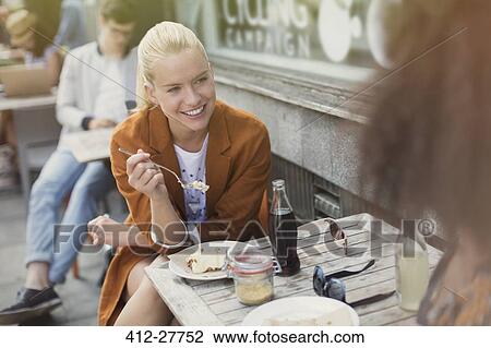 Smiling blonde woman eating dessert at sidewalk cafe View Large Photo Image Stock Image - Smiling blonde woman eating dessert at sidewalk cafe. Fotosearch