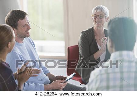Picture - Smiling business people talking in meeting. Fotosearch