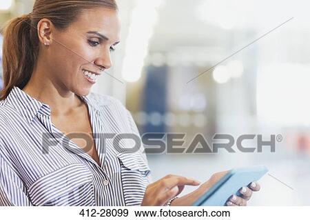 Stock Photo - Smiling businesswoman using digital tablet. Fotosearch