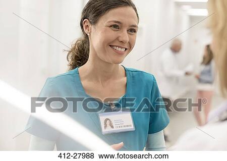 Stock Photo - Smiling nurse talking to doctor in hospital corridor. Fotosearch