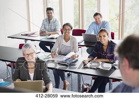 Smiling students watching teacher in adult education classroom View Large Photo Image Stock Photo - Smiling students watching teacher in adult education classroom. Fotosearch