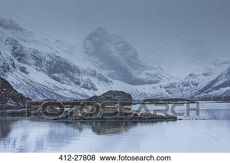 Snow covered craggy mountains over cold bay, Norway View Large Photo Image Stock Photo - Snow covered craggy mountains over cold bay, Norway. Fotosearch