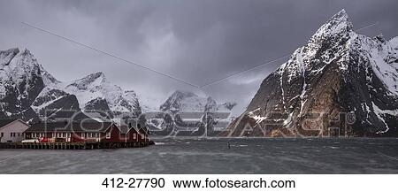 Stock Image - Snow covered mountain range above fishing village, Hamnoya, Lofoten Islands, Norway. Fotosearch